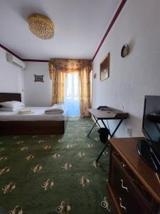 塔什干Heyvah - Guest House in Tashkent的一间卧室配有一张床、一张书桌和一台电视