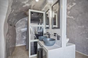伊亚Hostel 16 Oia的浴室设有两个水槽和镜子,位于隧道内