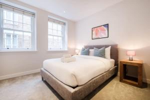 伦敦City of London - CityApartmentStay的一间卧室设有一张大床和两个窗户。