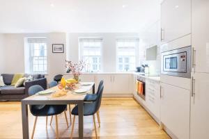 伦敦City of London - CityApartmentStay的厨房以及带桌椅的起居室。