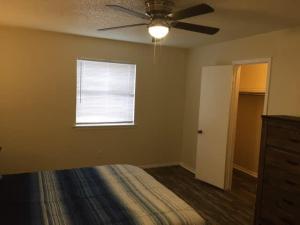 劳顿Simple 1-bedroom unit upstairs close to Fort Sill!的一间卧室配有吊扇和窗户。