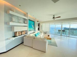 坎昆Departamento frente al mar的客厅配有白色家具,享有海景。