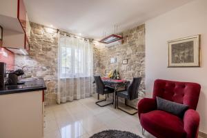 斯普利特里瓦长廊度假屋的厨房以及带红色椅子和桌子的客厅。