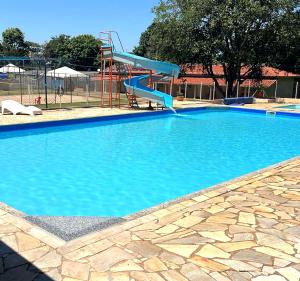 圣代佩德罗Ananda pousada chalé的一个带蓝色滑梯的大型游泳池