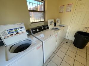 劳顿2BR 1Bath Downstairs Apartment near Fort Sill的洗衣房内的3台洗衣机和烘干机
