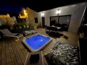 拉戈尔Maison T4 Climatisée avec Jacuzzi à Lagord的木制甲板上的大型热水浴池