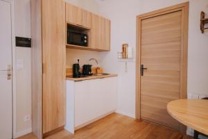 雷恩Apparts' Rennes BnB Solferino -Centre Gare的带微波炉和门的小厨房