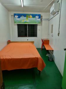 TuaranWISMA ORCHID HOMESTAY的配有橙色床单的床的房间