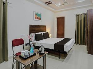 KondapurHotel White Ridge Near Kondapur的酒店客房配有一张床铺、一张桌子和一张书桌。