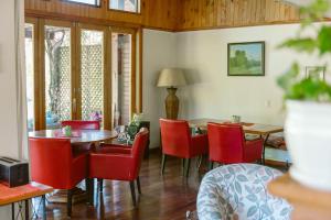 普孔Hotel Posada del Río - Parque Metreñehue的一间用餐室,配有红色的椅子和桌子