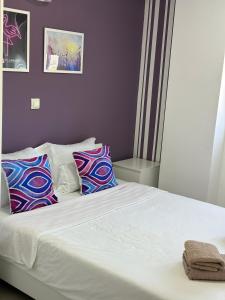 贝尔格莱德Flamingo Resort的卧室配有白色的床和色彩缤纷的枕头