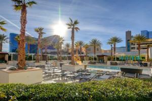 拉斯维加斯MGM Signature-04-704 Jacuzzi Studio的一个带游泳池、棕榈树和椅子的度假酒店