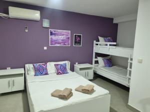 贝尔格莱德Flamingo Resort的一间卧室设有两张床和紫色墙壁