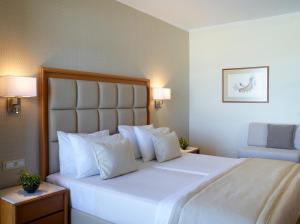 法里拉基阿波罗海滩酒店的卧室配有白色大床和白色枕头