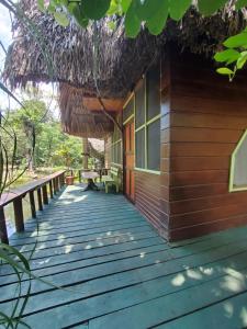 里约杜尔塞Hotel Casa Perico的通往茅草屋顶小屋的木制走道