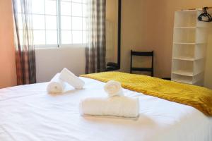 蓬塔德尔加达Vieira Rooms Natural Pools的一间卧室配有带毛巾的床