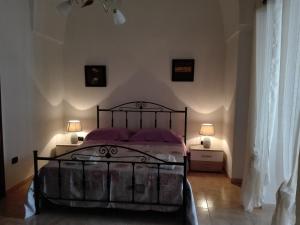 曼杜里亚Il melograno b&b的一间卧室配有一张黑色的床和两盏灯。