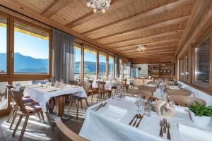 罗登戈Obergasserhof的餐厅设有白色的桌椅和窗户。