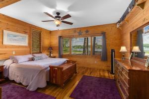 RockfordLakefront 5BR Cabin on Big Crooked Lake w Pontoon的一间卧室配有一张床和吊扇