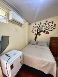 萨尔瓦多Hostel Sol da Barra的卧室配有一张床铺,墙上挂着一棵树