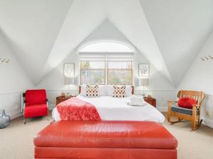 加蒂诺Stunning waterfront home 25min to downtown Ottawa的一间卧室配有一张床和两张红色椅子