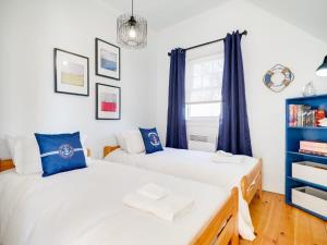加蒂诺Stunning waterfront home 25min to downtown Ottawa的卧室内的两张床,配有蓝色窗帘