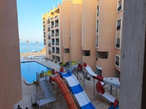 赫尔格达Juliana Beach Hurghada的一座带游泳池的建筑前方的水滑梯