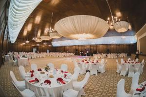 拉姆尼库沃尔恰Hotel Posada的一个带白色桌子和白色椅子的大型宴会厅