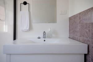 Kings ParkStation Cottage的白色的浴室设有水槽和镜子