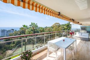瓦洛里Magnifique vue mer panoramique的阳台享有房屋的景致,配有桌椅