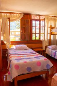奥克萨潘帕HOSPEDAJE SCHASCA的一间卧室设有两张床和窗户。