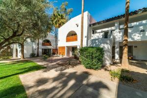 卡萨格兰德78- Modern Casa Grande Desert Paradise heated pool的一座白色的建筑,前面有棕榈树