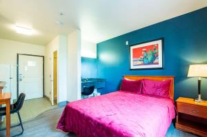 谢拉维斯塔Sierra Vista studio apartment with full kitchen and King Bed的一间卧室设有粉红色的床和蓝色的墙壁