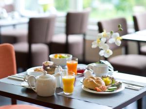 斯图加特ACHAT Hotel Stuttgart Zuffenhausen的包括一盘食物和橙汁的早餐桌