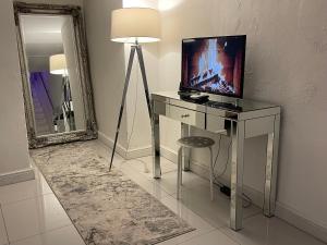 卡迪夫Cwtch Cardiff Bay的客房设有一张带电视和镜子的书桌