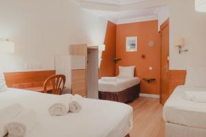 巴黎玛丽格南酒店的酒店客房设有两张床和一张桌子。
