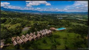 塔拉波托HOTEL RUSTICA TARAPOTO的享有房子和游泳池的空中景致