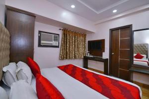 新德里Hotel Kabeer By A1Rooms的一间卧室配有一张带红色毯子的床