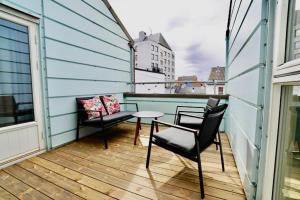 波什格伦Sentralt i rolig bygård, med heis, egen, veranda & 85" Smart TV的阳台的天井配有2把椅子和1张桌子