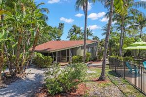 萨尼贝尔Renovated Cottage at the Historic Palms Inn of Sanibel- Includes Pool and Bikes的一座带围栏和棕榈树的房子