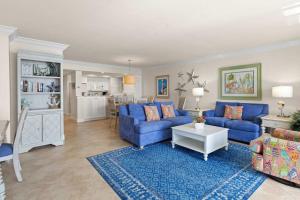 迈尔斯堡Gorgeous Renovated Residence in Upscale Sanibel Harbour Tower的一间带蓝色沙发的客厅和一间厨房