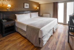 乌斯怀亚乌斯怀亚论诺克斯酒店的卧室内的一张大床,铺有木地板