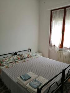 阿梅利亚Appartamenti Fiumaretta MT 200 dalla spiaggia的一间卧室配有一张床,上面有两条毛巾