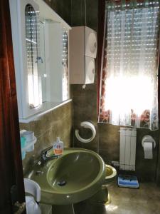 阿梅利亚Appartamenti Fiumaretta MT 200 dalla spiaggia的一间带绿色水槽和窗户的浴室