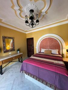 阿瓜斯卡连特斯Hotel La Casa de María Joyita的一间卧室配有一张大床和一个吊灯。