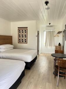 雷德布拉夫Triangle Motel的一间卧室配有两张床和一张桌子