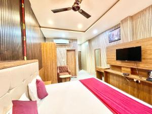 瓦拉纳西HOTEL SIDDHANT PALACE ! VARANASI fully-Air-Conditioned hotel at prime location, Lift-&-wifi-available, near-Kashi-Vishwanath-Temple, and-Ganga-ghat的配有一张床和一台平面电视的酒店客房