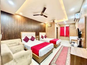 瓦拉纳西HOTEL SIDDHANT PALACE ! VARANASI fully-Air-Conditioned hotel at prime location, Lift-&-wifi-available, near-Kashi-Vishwanath-Temple, and-Ganga-ghat的一间带两张床和一张沙发的卧室
