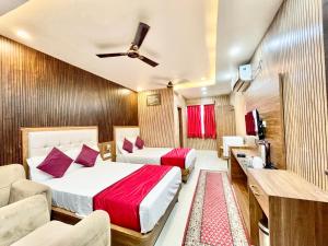 瓦拉纳西HOTEL SIDDHANT PALACE ! VARANASI fully-Air-Conditioned hotel at prime location, Lift-&-wifi-available, near-Kashi-Vishwanath-Temple, and-Ganga-ghat的酒店客房,设有两张床和一张沙发