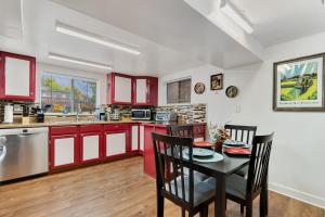 丹佛Cozy & Spacious Apartment Steps From Regis的厨房配有红色橱柜和桌椅